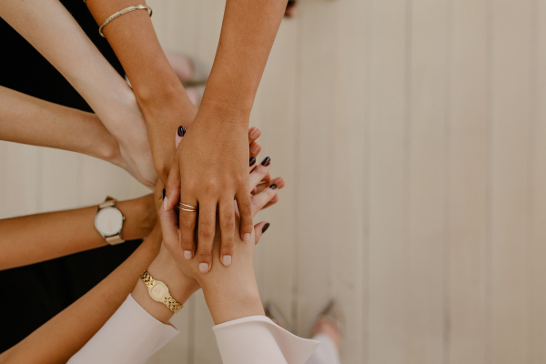 Hands joined together symbolizing collaboration and shared support among independent travel advisors