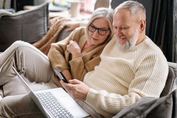Happy couple booking cruise vacation online after engaging with travel advisor video funnel
