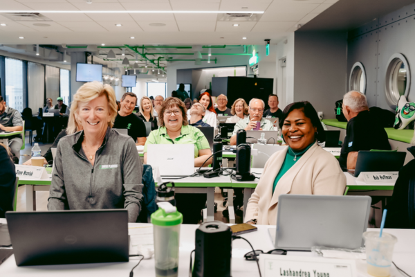 Travel agents attending training session with laptops in a modern office setting