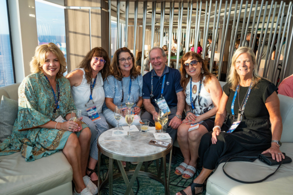 Travel advisors relaxing and networking in lounge area aboard Norwegian Encore