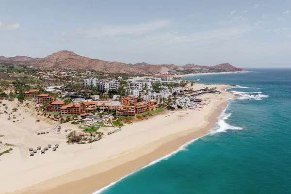 Aerial view of Zoetry Casa del Mar Los Cabos resort with pool, palm trees, and mountain backdrop along the Sea of Cortez