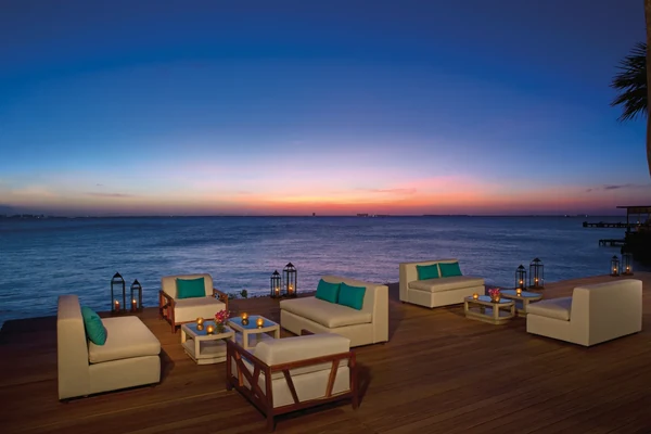 Oceanfront sunset lounge deck at Zoetry Villa Rolandi Isla Mujeres with white furniture and teal accents