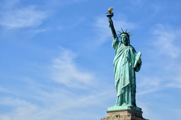 Statue of Liberty against a blue sky in New York Harbor, the iconic starting point of an East Coast multi-destination American Stories Travel journey