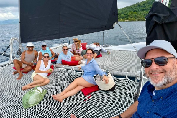 Michelle Fee, Founder and CEO of Cruise Planners, and Theresa Scalzitti, Chief Operations Officer, lounging with franchise owners and suppliers aboard a catamaran in Tahiti