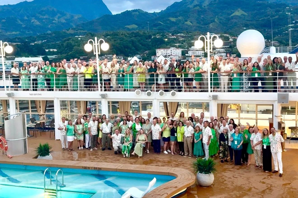 150 Cruise Planners franchise owners gather aboard a Silversea ship in Tahiti for the 2026 Elite Summit, dressed in green for the Millionaires Club celebration