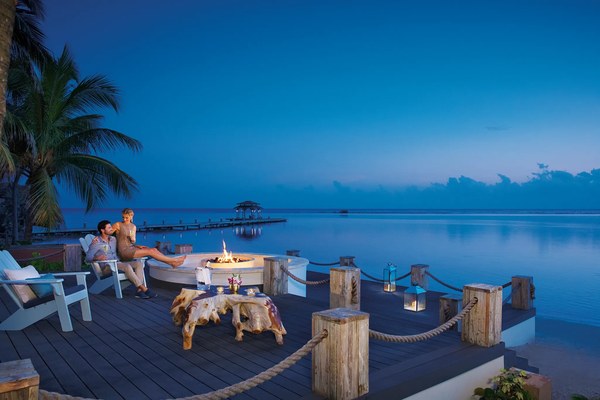 Romantic couple at a firepit on the dock at twilight overlooking the Caribbean Sea at Zoëtry Montego Bay, Jamaica
