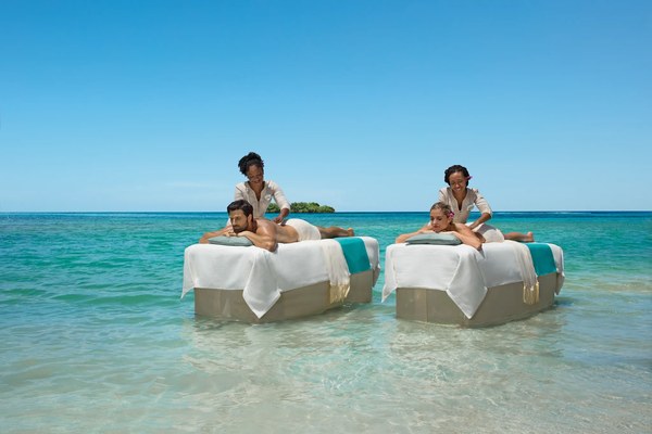 Couples massage on floating tables in the shallow turquoise Caribbean Sea at Zoëtry Montego Bay, Jamaica