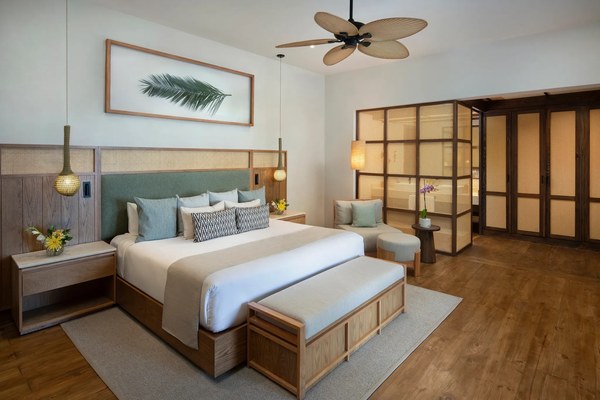 Spacious king suite at Zoëtry Agua Punta Cana with palm frond ceiling fan, sage green headboard, and a framed palm leaf print