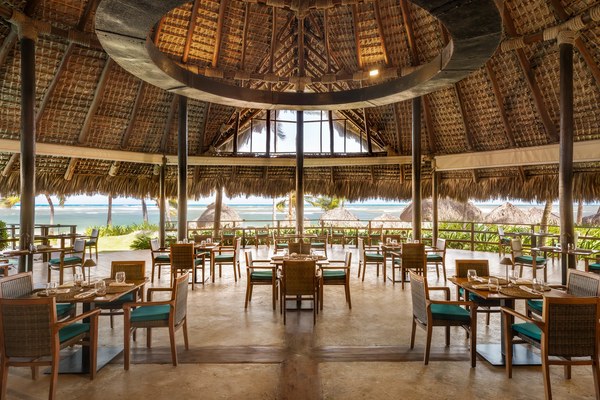 Indigo restaurant at Zoëtry Agua Punta Cana with palapa-thatched cathedral ceiling and ocean views beyond the open-air dining room