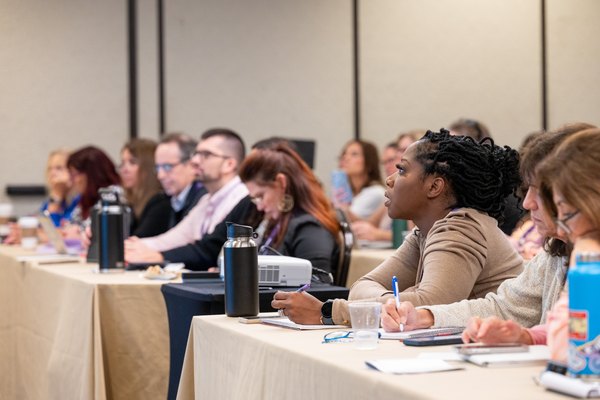 Travel advisors focused and taking notes during a working education session at a Nexion Travel Group event