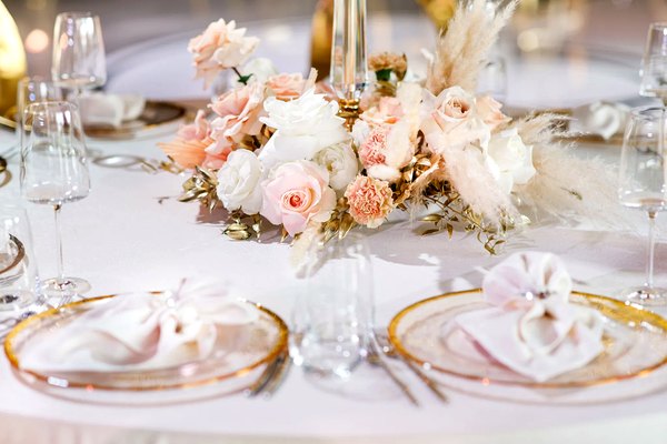 Elegant wedding table setting with roses and gold accents